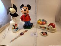 Full view showing all five Disney Mickey Mouse themed items in the lot including fan, bank, Color Spin, ring, and watch.