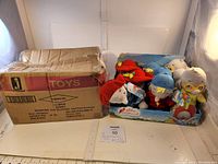 Full view of 9 plush toys in original display case and damaged outer box