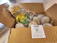 Open box showing 9 Ella the Elephant plush toys sealed in plastic inside the shipping carton.