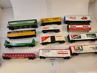 Full lot view showing 12 HO scale railroad cars of various brands and colors arranged in rows