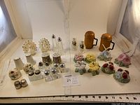 Full overview of all 16 sets of salt and pepper shakers showing a variety of materials and styles such as floral, fruit, and textured glass.