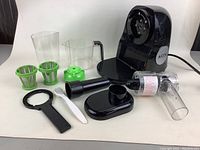 Full view of all disassembled parts of the Aicok juicer including main unit, filters, containers, pusher, wrench, and cleaning brush.
