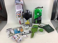 Overview of assorted kitchenware items including peeler, juicer, graters, packaged eco-bags, and storage box