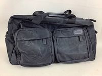 Front view of black nylon Lipault Paris travel bag showing two zippered front pockets and carrying handles.