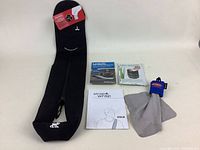 Full lot showing black neoprene DSLR shoulder strap, LensSavrz cleaning cloth, Lens Cleanse wet wipes, and microfiber cleaning cloth with clip.