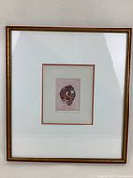 Framed entire artwork showing frame and matting with etching in center