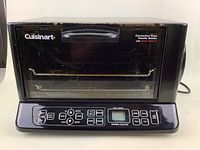 Front view of Cuisinart toaster oven showing door, handle and control panel with brand logo