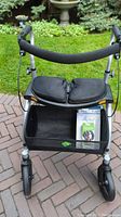 Front view of walker showing seat, storage basket, wheels and foam handles