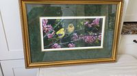 Full view of the framed print showing two yellow birds on green and pink blossom background with ornate gold frame.