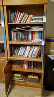 Bookshelves filled with various books including series and standalone titles, organized on multiple shelves.