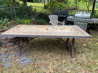 Full view of the rectangular table showing tile top, metal frame, and surrounding area.