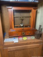 Wood and glass scale with brass beam, mortar and pestle, four buttons