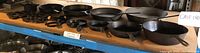 Wide view of cast iron skillets and accessories on shelf