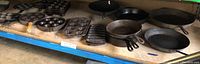 Shelf overview of assorted cast iron skillets and bakeware molds
