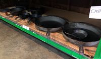 Shelf view showing large flat and deep skillets through to smaller pieces