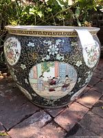 Side view of large ceramic pot showing Chinese hand-painted scenes and floral motifs.