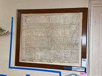 Full view of framed large indenture contract on vellum, mounted on wall, showing overall condition and size relative to wall and door.