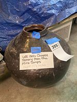 View of the full pottery vessel showing size, shape and overall condition with an identification label stating 'Late 1800s Chinese Pottery from the Mine Camps Height 13 3/4 inches'.