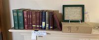 Books arranged on shelf including American Association of Petroleum Geologists Bulletins, mineral industry books, and certificate in frame.