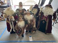 Group photo showing seven varied decorative Santa figures with different outfits and accessories on concrete floor.