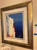 Photo of framed giclee art showing the figure with white building and blue background, signed by Emile Bellet.