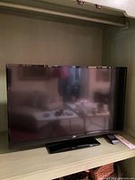 Full front view of JVC 32-inch TV showing screen, bezel, and base stand.