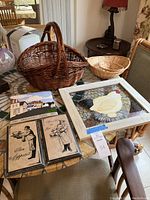 Photo showing the arrangement of two woven baskets, a framed nesting hen wall decor featuring painted yellow hen and chicken wire background, and several decorative plaques including Bon Appetit signs.