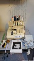 Front view of serger with spool stand and threads