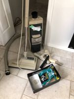 Electrolux vacuum unit with attached hose and wand. Motorized floor head on floor, nearby accessories including crevice tool and hard floor nozzle, vacuum bags in package.
