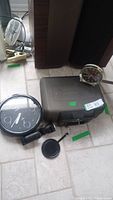 Photo showing SentrySafe safe with keys, Big Ben alarm clock, Lorus wall clock, and clip-on light on floor