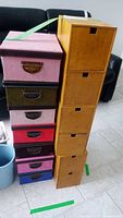 Two stacks of storage boxes, one colorful with fabric drawers and one wooden with natural finish drawers