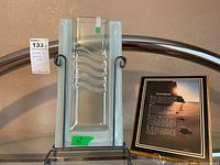 Rectangular wavy glass vase held by black metal stand with Footprints poem plaque behind it