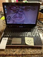 Front view of HP 15-inch laptop showing screen, keyboard, touchpad, and stickers noting broken hinge and untested status.
