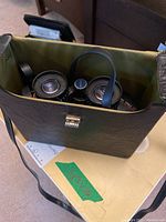 Selsi binoculars inside their black carrying case with strap and clasp.
