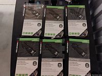 Six Monster iCarCharger MAX 2 USB car chargers in original packaging arranged on a surface, showing front packaging with branding and visible devices.