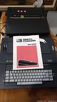 Smith Corona SD300 typewriter with manual placed on keyboard showing layout and condition.