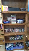 Shelf with portable stereo cassette player, stacks of CDs, and small cases