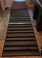 Two rubber-backed entry mats laid on tiled floor, showing striped pattern and size