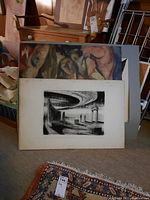 Four art pieces stacked with some prints in front and abstract paintings behind, showing textures and colors.