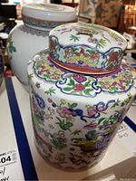 Close-up image of ginger jars showing colorful famille rose floral patterns and lids