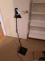Full view of floor lamp showing lamp, arm, shade, and base