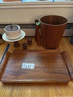 Photo showing the full set on the floor including wood tray, waste bin, salt and pepper shakers, wood bowl with cover, and candle holders.