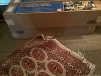 Two long sealed cardboard boxes containing flat-pack chair kits on carpet
