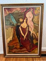 Full view of vintage framed abstract figurative painting showing two stylized female figures with earthy tones, set in a gold frame with beige linen liner.