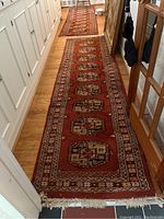 First runner in foreground with second in background laid along hallway floor