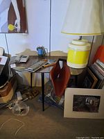 Small rectangular wooden table with dark brown veneer top and black hairpin legs, shown with miscellaneous items on top