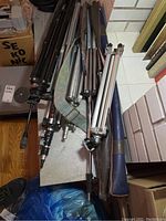 Top view of six tripods stacked together showing metal legs and adjustment knobs