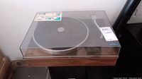 Turntable in wood veneer base with clear dust cover closed