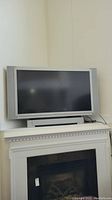 Front view of the Panasonic HDTV on a white mantel, showing the entire screen and base stand.