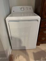 Full front view of the white GE dryer showing door and surrounding area.